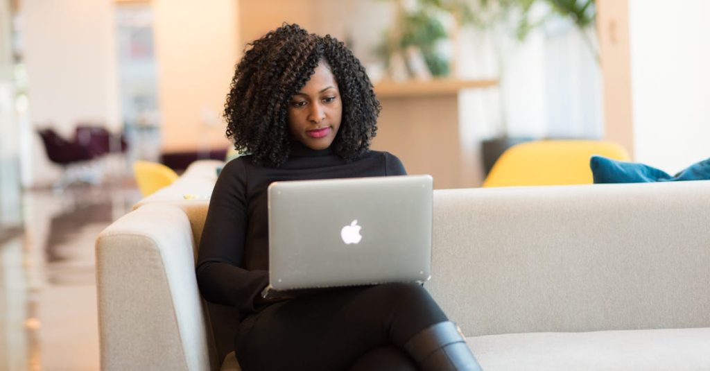 Should I Change Careers in Midlife? An African American woman working remotely on a laptop in a modern indoor setting.