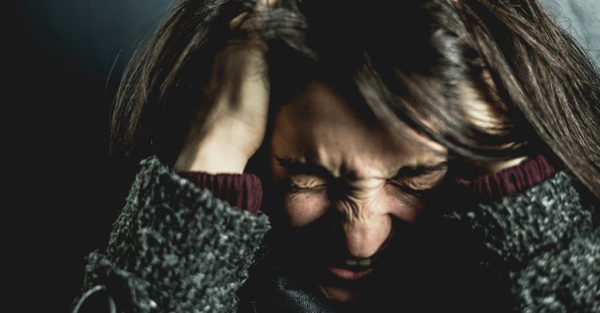 Is rage during perimenopause normal? A women clutches her head in anger or frustration