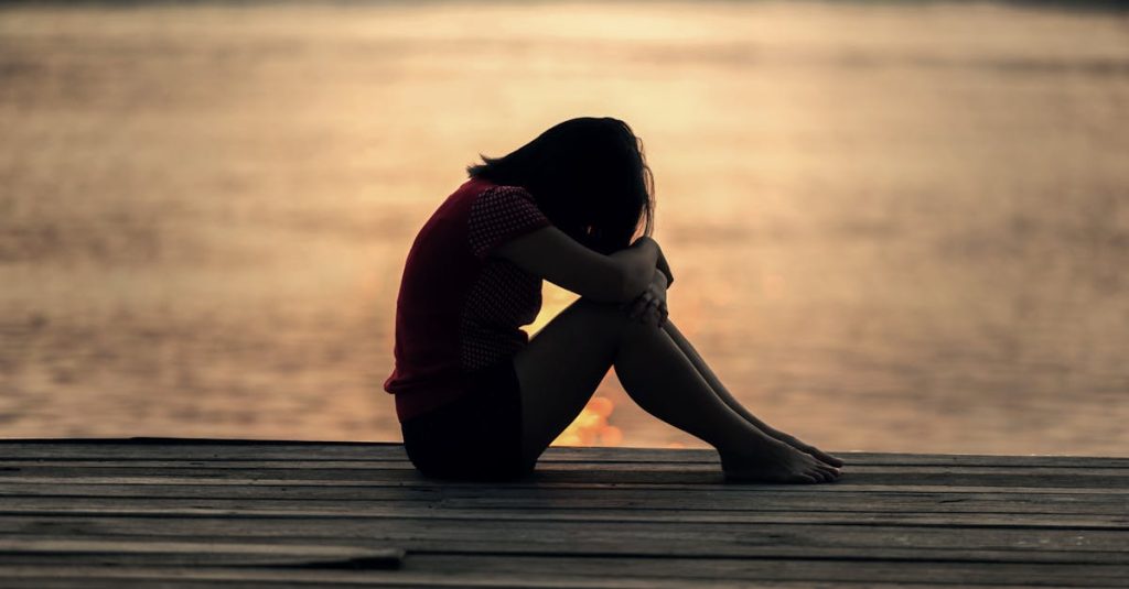 sad teen on dock. how to support a tween who is being body shamed