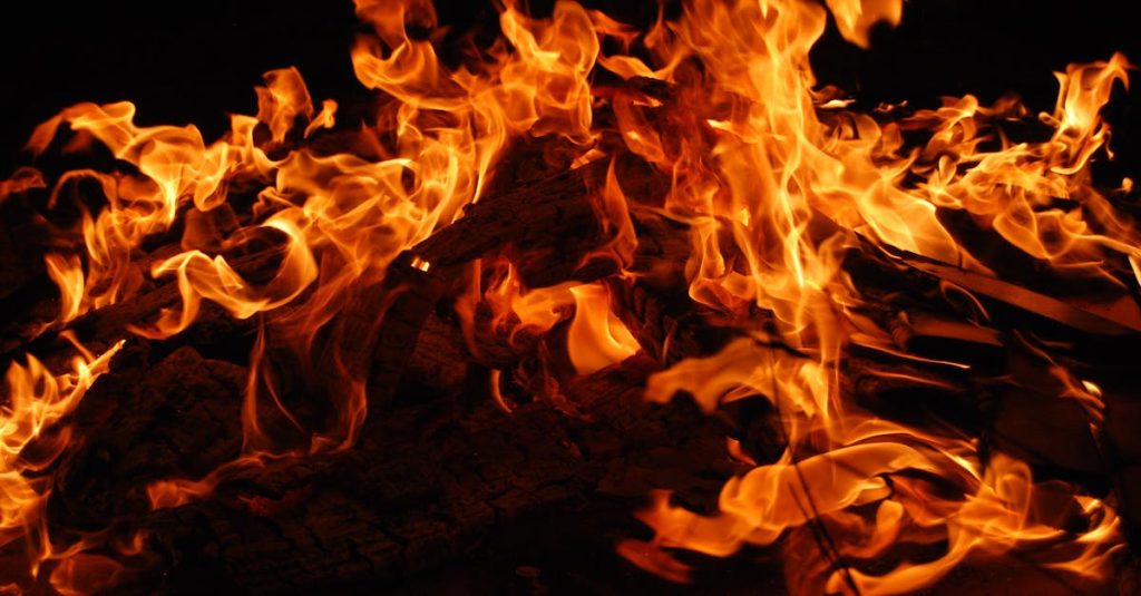 Is this a hot flash? Close-up of a blazing bonfire with intense flames against a dark background.